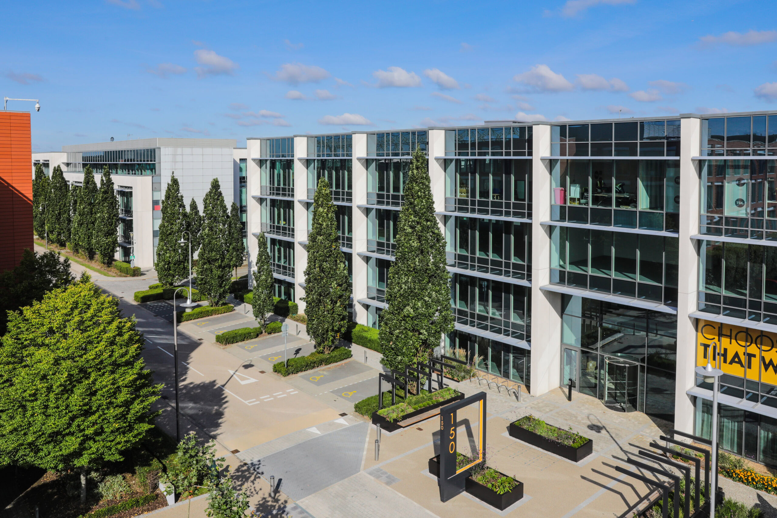 A sleek business park featuring modern office buildings with large glass windows