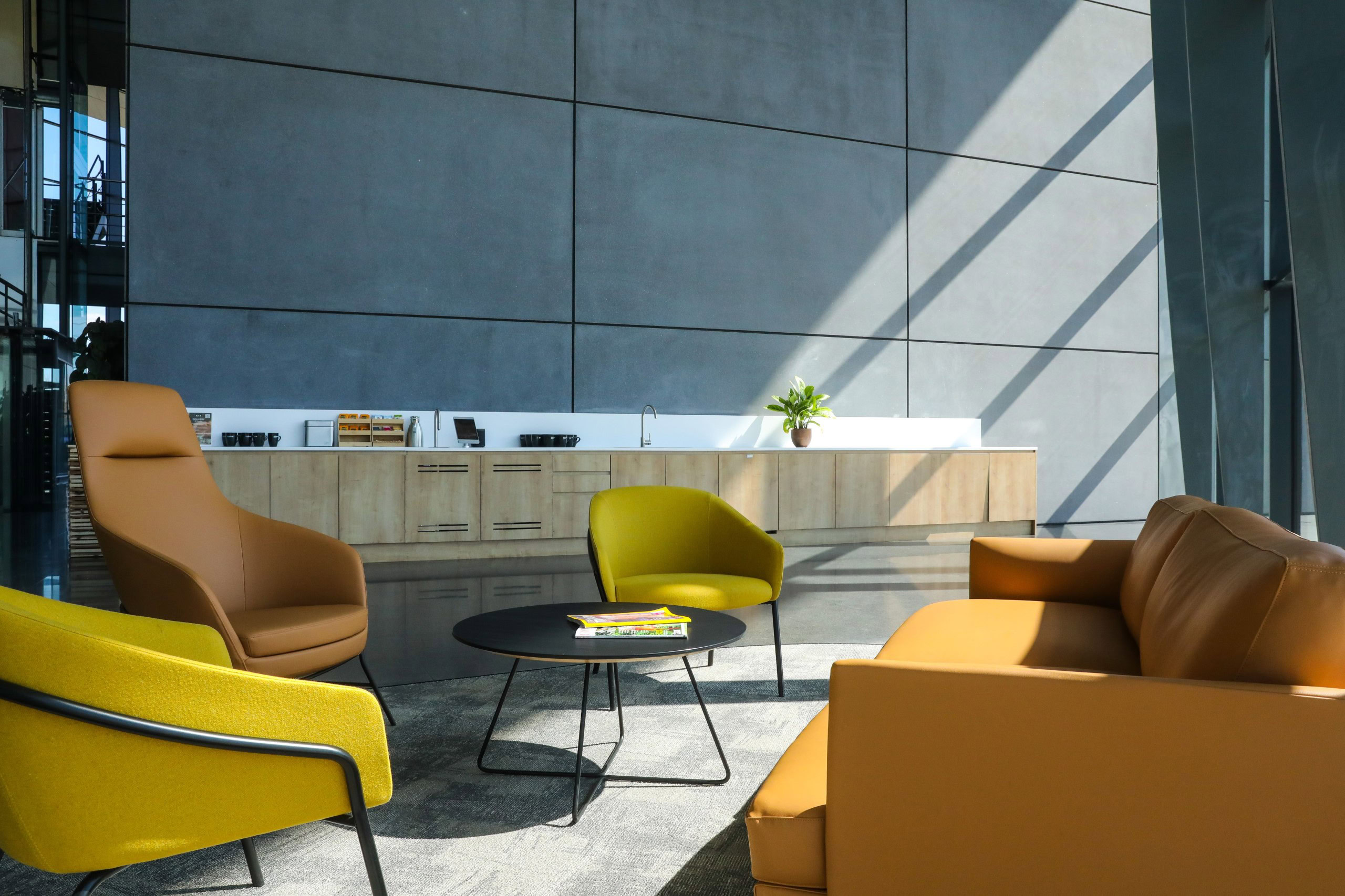 Modern lobby in an office building with sunlight streaming in through large windows