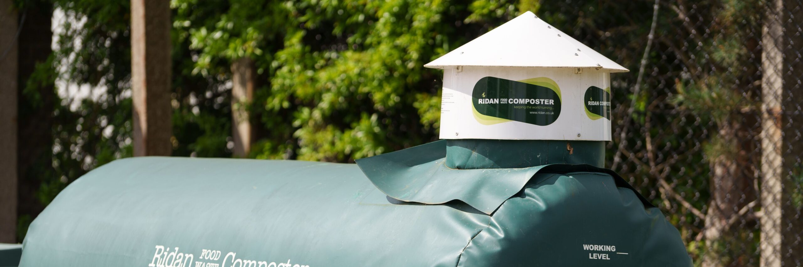 Close-up of a green Ridan food composter outdoors